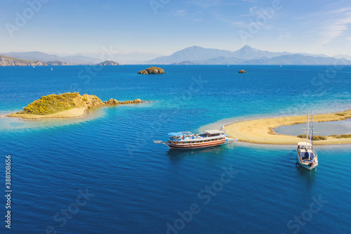 view to two boats and sand cape with mountains in horizon with copy space © sergejson