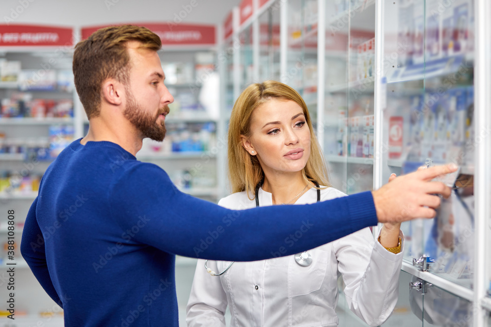 male customer having a discrete talk with druggist in pharmacy, ask for advice, pharmacist woman help, ask for symptoms male customer having a discrete talk with druggist in pharmacy, ask for advice, pharmacist woman help, ask for symptoms