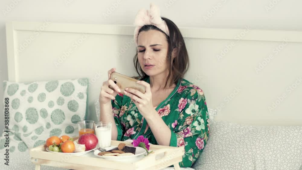 Happy woman playing game on smartphone sitting on bed at home, 4K
Happy woman playing game on smartphone sitting on bed at home, 4K