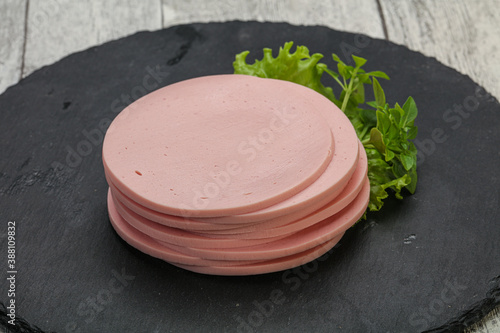 Foto Sliced pork natural sausages over board