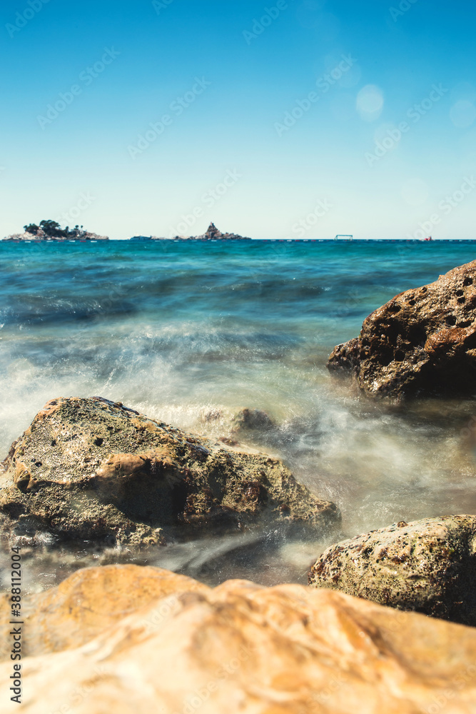 Sea wave crashes against rocks - long exposure and blur - power of water