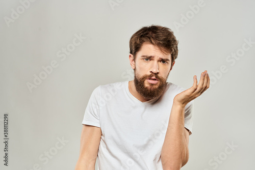 man in white t-shirt gesturing with his hands studio dissatisfaction lifestyle light background