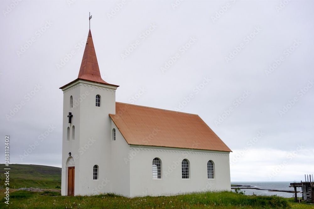 White old Kollafjardarneskirkja Christian church at Western Iceland near Holmavik in cloudy weather
