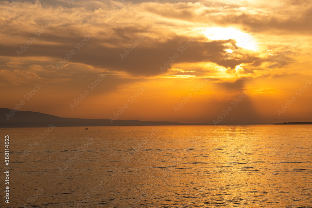 sunset view on the lake. a fishing boat in the lake. sunset view on the lake. a fishing boat in the lake.