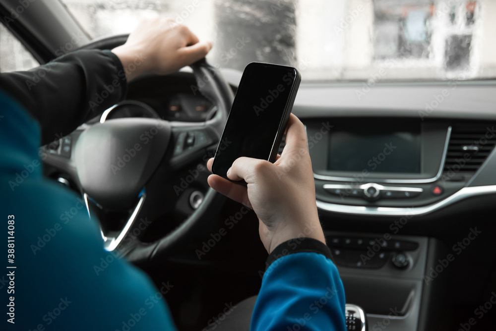 Naklejka premium Man using mobile phone in the car. Driving car. Danger. 