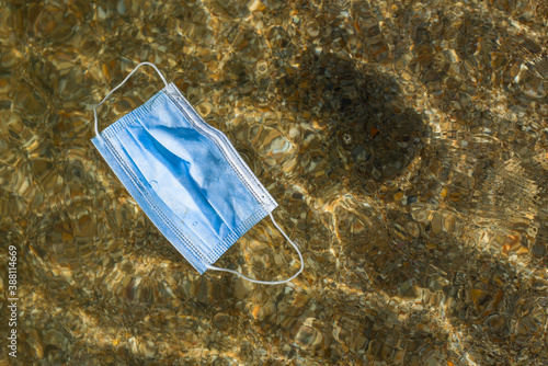 The medical mask drifts in the sea. Water pollution. photo