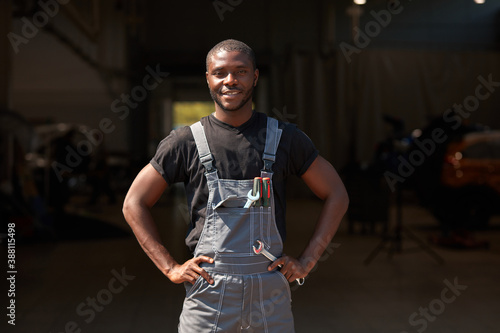 portrait of confident successful auto mechanic man of african appearance, young male likes working with cars, repairing. take a break, posing at camera © alfa27