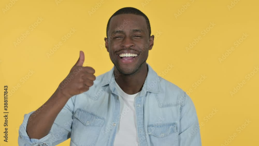 Young African Man with Thumbs Up, Yellow Background Young African Man with Thumbs Up, Yellow Background