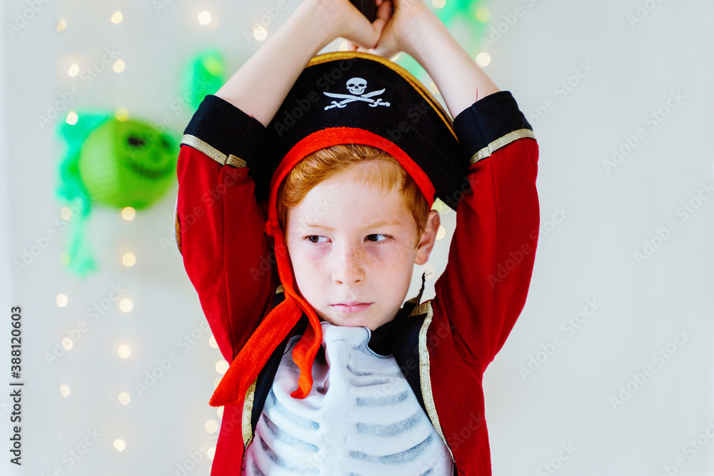 Horizontal view of little caucasian kid playing with Halloween pirate costume at home. Seasonal and festive Halloween party concept. Horizontal view of little caucasian kid playing with Halloween pirate costume at home. Seasonal and festive Halloween party concept.
