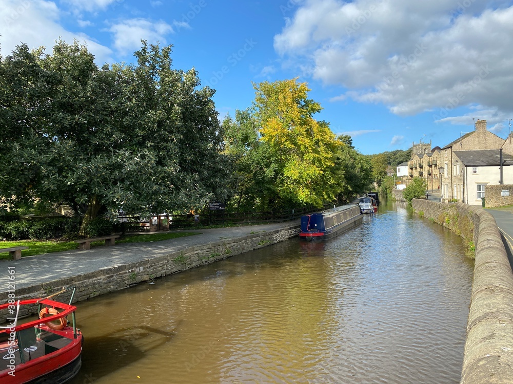 Boats on the Leeds to Liverpool canal, with old trees, and houses on the canal banks in, Skipton, Yorkshire, UK Boats on the Leeds to Liverpool canal, with old trees, and houses on the canal banks in, Skipton, Yorkshire, UK