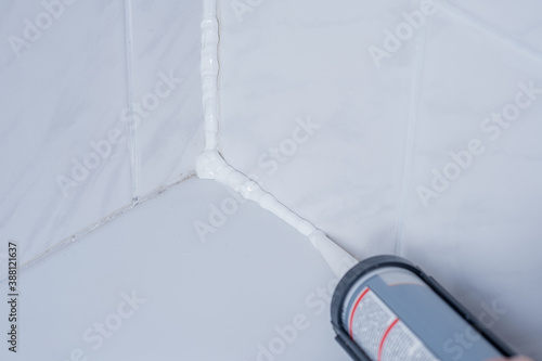 Obraz na płótnie Plumber Applying silicone sealant to the tile joint w salonie