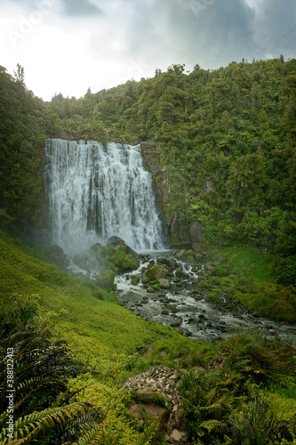 Marokopa Falls  North Island of New Zealand. Landscape scenery of the Zealand waterfall  cloudy sky ang green forest around