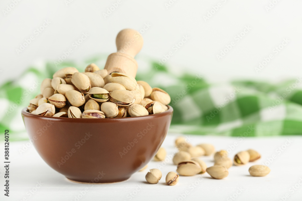 Pistachios in bowl on white wooden table Pistachios in bowl on white wooden table