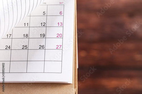 Paper calendar page on brown wooden background
