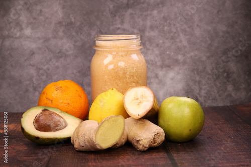 Delicious tropical Smoothie with orange, banana, apple, lemon, avocado, and ginger photo