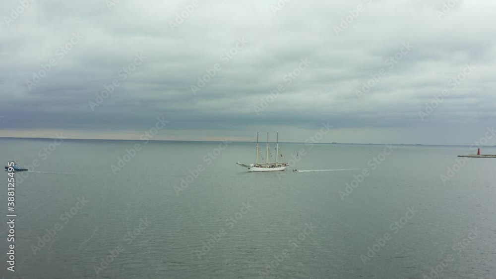 Aerial view of a large sailing ship with high masts entering the port of Gdansk, Poland. An old ship with masts carries tourists across the Baltic Sea.