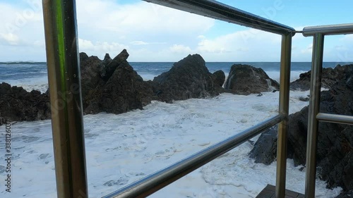 Big waves crashing against the rocks and splashing foam several meters up