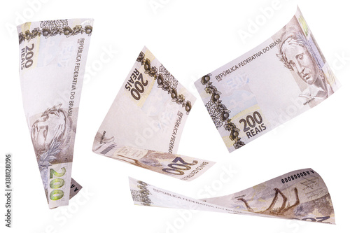 200 reais banknotes, bank notes falling on isolated white background. Two hundred reais from brazil, selective focus. Fall, inflation and loss concept photo