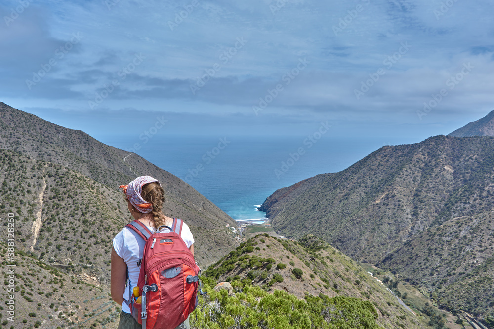 Hiking through the panoramic mountain landscape in La Gomera, Spain. Hiker in the mountains in La Gomera, Spain. View from the mountains in La Gomera on the ocean.