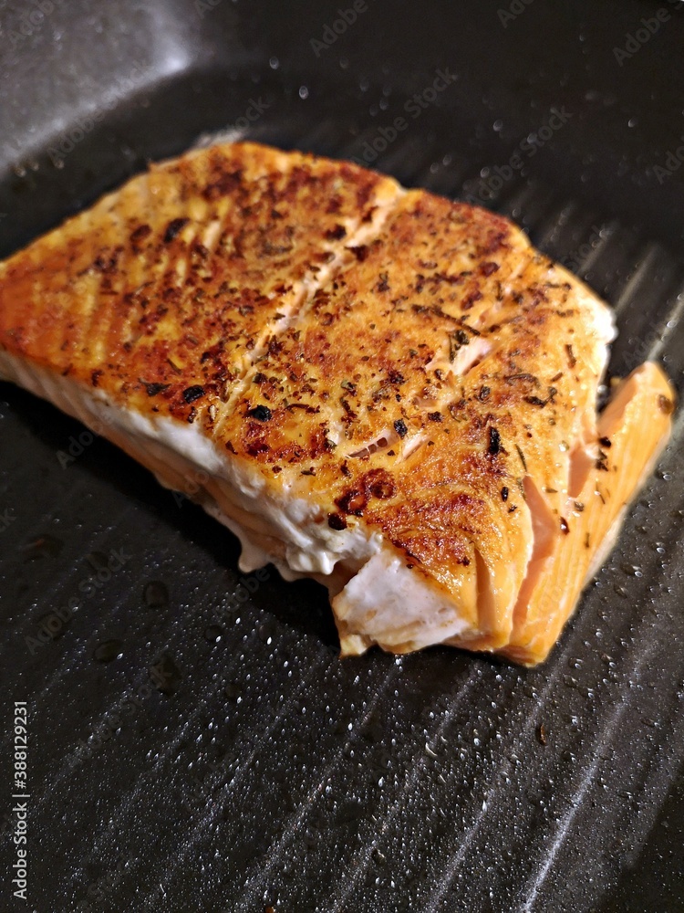 Cooking salmon with herbs on a frying pan Cooking salmon with herbs on a frying pan
