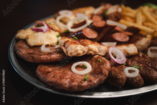 several types of roasted meat served on an oval, Serbian dish "Mixed meat"
