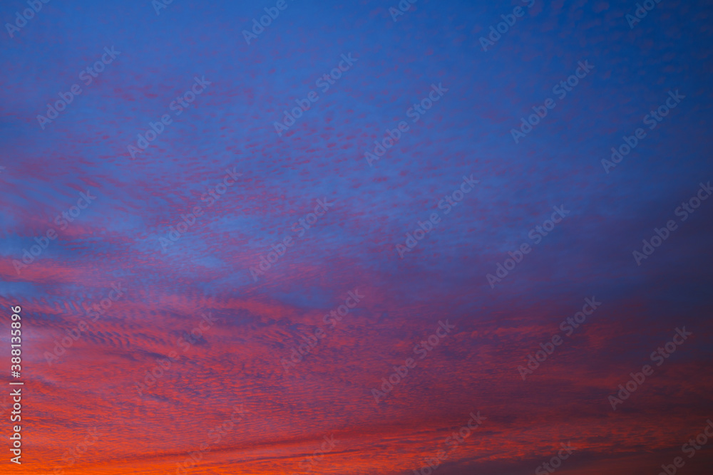Blue sky and red broken clouds background.