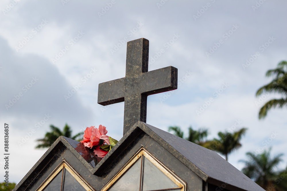 Detalhe de cruz em um túmulo em cemitério.