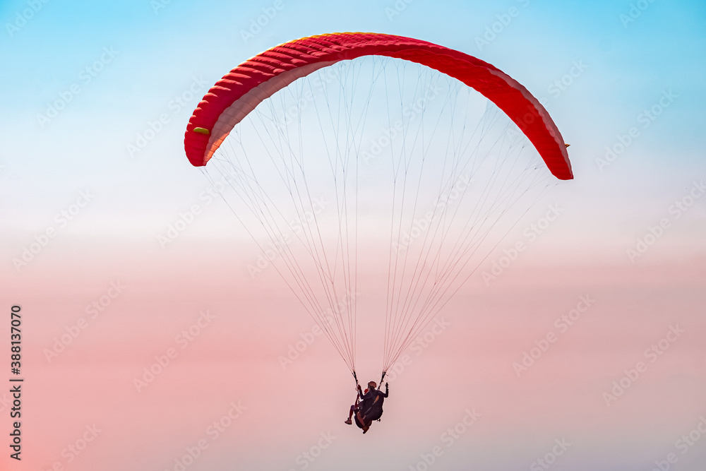 Paragliding in the sky. Paraglider tandem flying over the sea with mountains at sunset. Aerial view of paraglider and Blue Lagoon in Oludeniz, Mugla, Turkey. Paragliding in the sky. Paraglider tandem flying over the sea with mountains at sunset. Aerial view of paraglider and Blue Lagoon in Oludeniz, Mugla, Turkey.