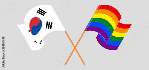 Crossed and waving flags of LGBTQ and South Korea