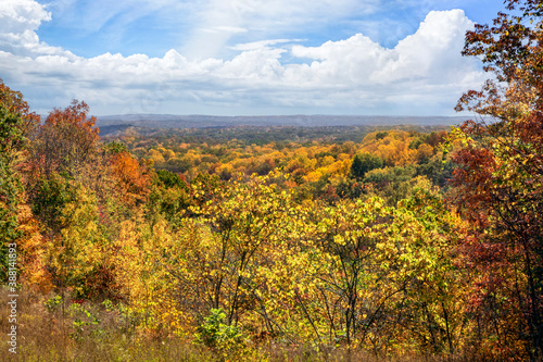 Brown County State Park in Indiana is renowned for it beautiful fall foliage vistas showing autumn leaves in many colors under a cloudy blue sky.