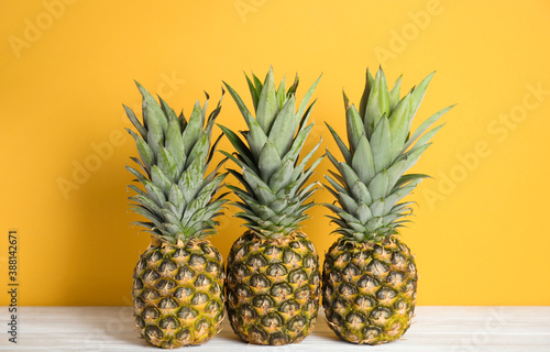 Fresh ripe juicy pineapples on white wooden table