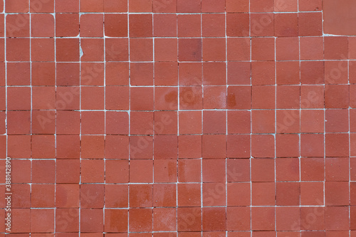 Wall texture with brick-colored facade tiles. Facade of a building with mosaic tiles