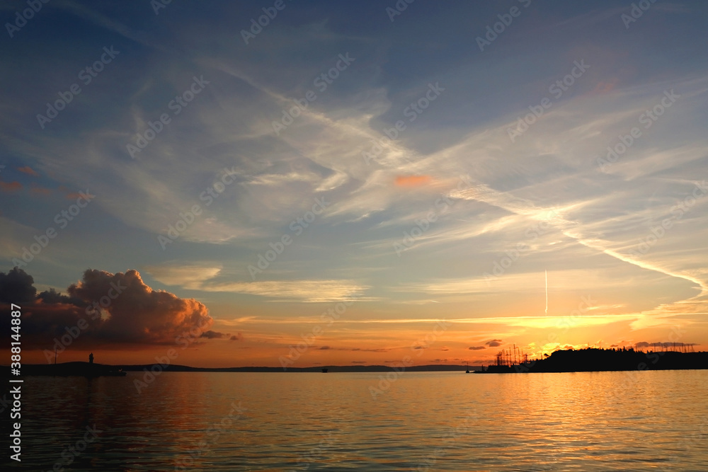 Naklejka premium Beautiful sunset over the sea with lighthouse silhouette, in Split, Croatia.