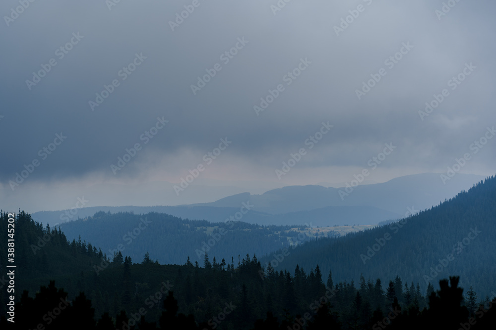 Naklejka Dusk in the mountains before a storm and a thunderstorm on a rainy and foggy day. Severe weather conditions. Peaks of the Carpathian Mountains