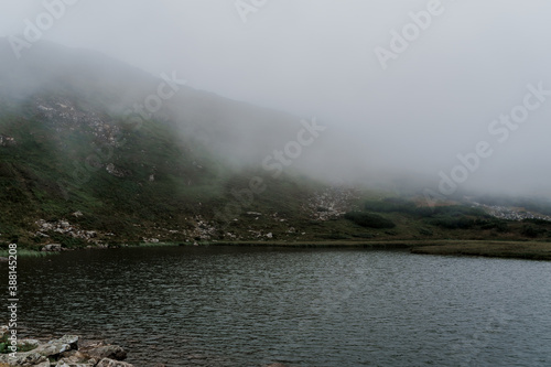 Mountain lake full of fog in rainy day. Windy and storm weather in the karpathian mountains