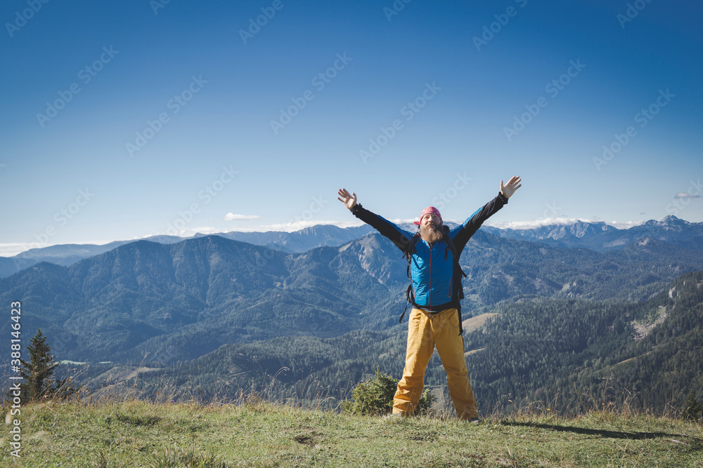Mature man with arms raised standing on mountain against clear sky, Otscher, Austria
