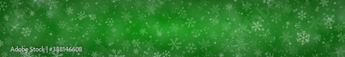 Christmas banner of snowflakes of different shapes, sizes and transparency on green background