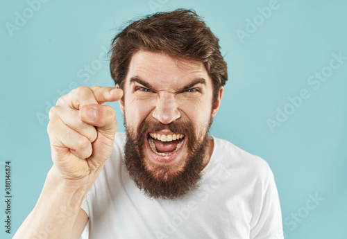 Emotional bearded man on a blue background cropped view of gesticulating with his hands