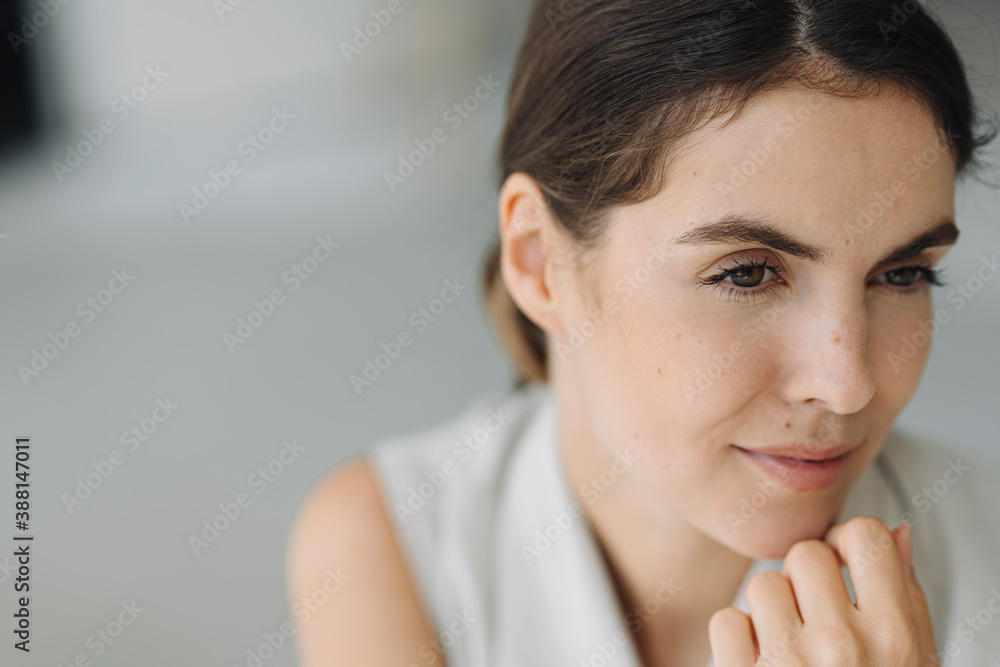 Thoughtful young woman with hand on chin sitting at office Thoughtful young woman with hand on chin sitting at office