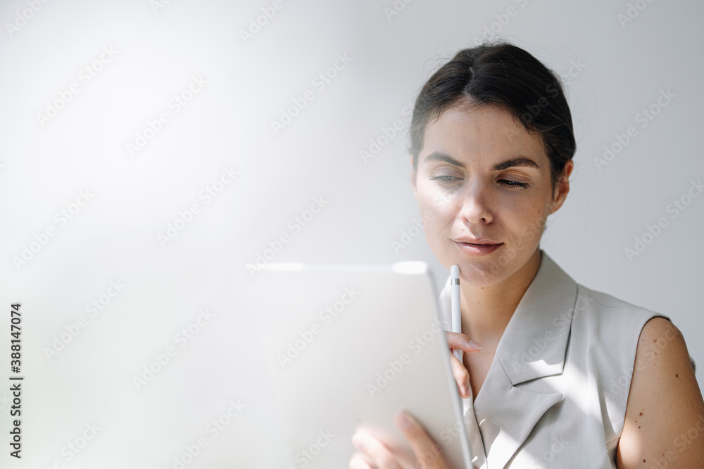 Thoughtful businesswoman using digital tablet at office