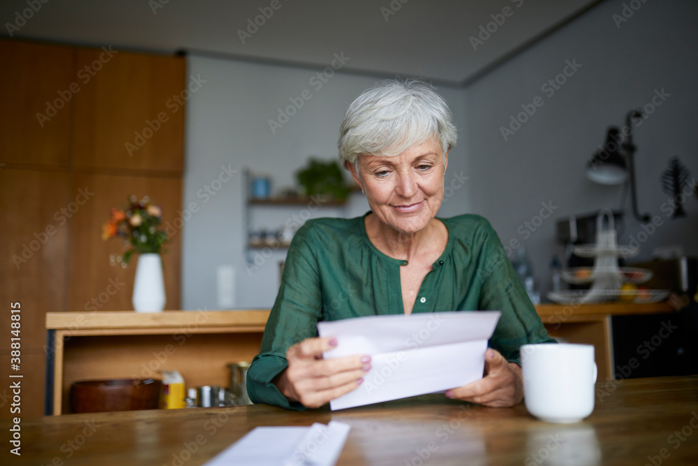 Senior woman reading letter while sitting at home Senior woman reading letter while sitting at home