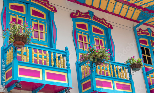 Balconies and windows in red, blue, green, yellow, with gardens and flowers, in the coffee region in Colombia photo