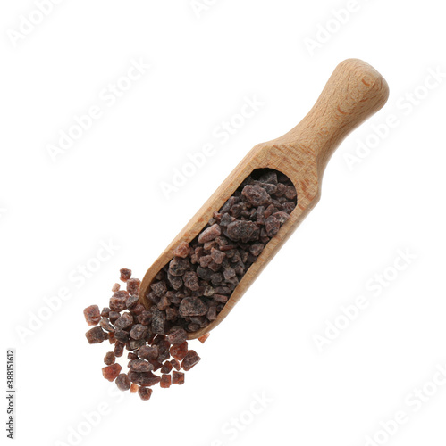 Black salt in wooden scoop on white background, top view