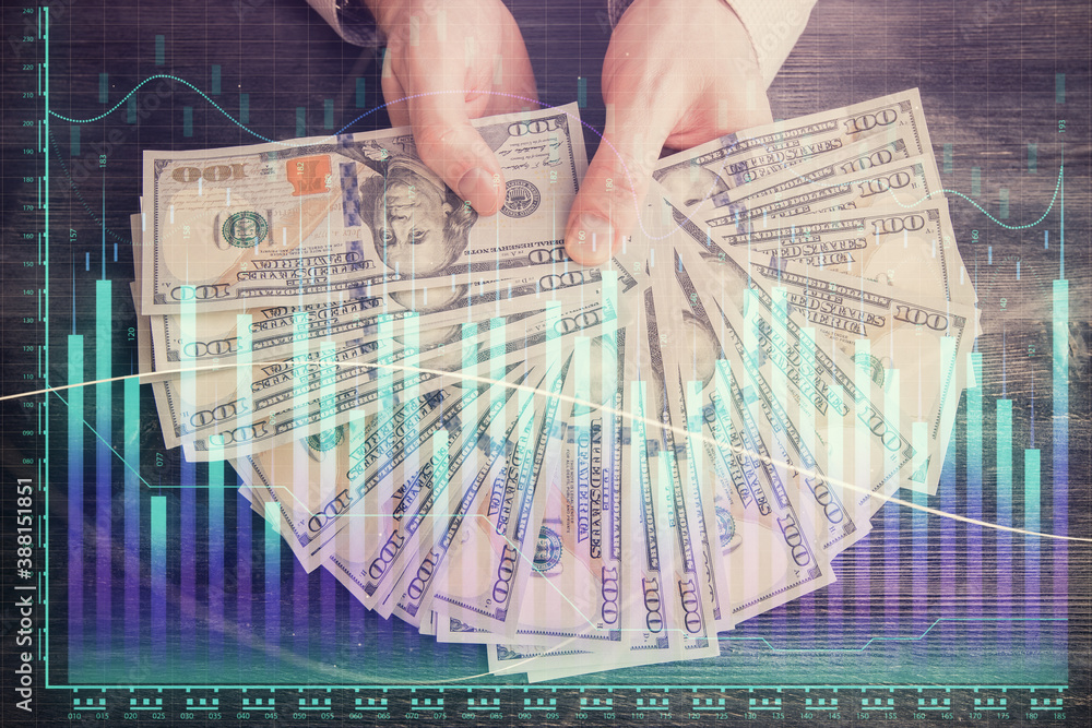 Multi exposure of financial graph drawing hologram and USA dollars bills and man hands. Analysis concept.