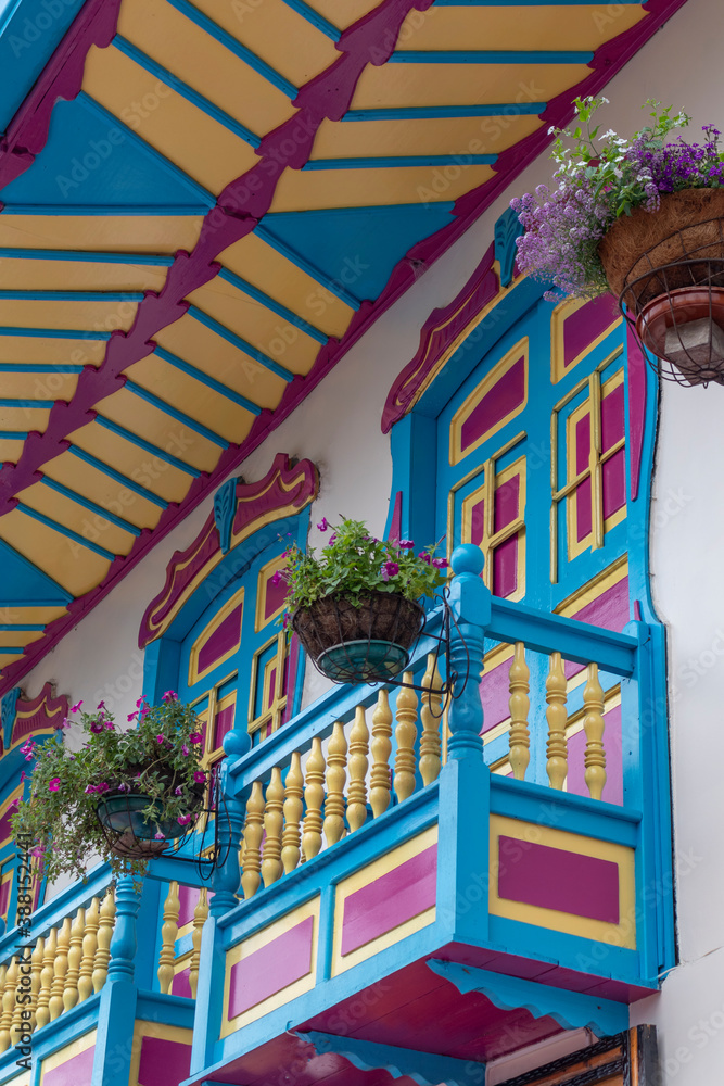 Balconies and windows in red, blue, green, yellow, with gardens and flowers, in the coffee region in Colombia