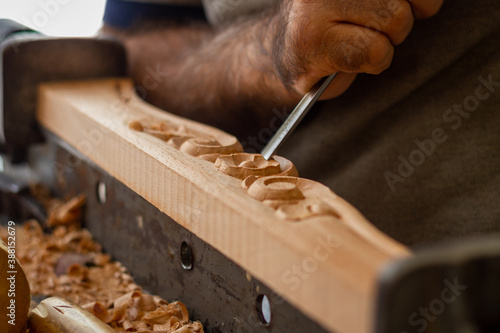 Carpenter working on wooden furniture with hand carving. Wood carving art with hand tools
