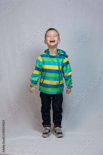 boy 3-6 years old wearing a jacket laughs loudly. overall plan