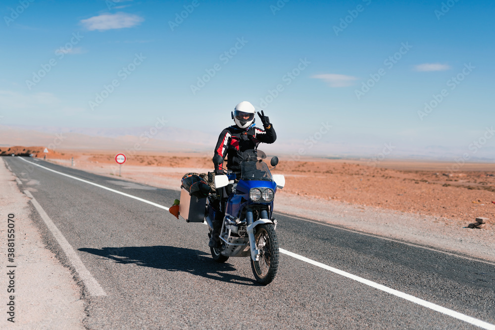Biker riding an adventure motorcycle in Morocco desert Biker riding an adventure motorcycle in Morocco desert