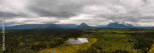 Peaceful Panoramic View of Pond and Marshland, surrounded by Forest and Mountains in Canadian Nature. Aerial Drone Shot. West of Whitehorse, East of Haines Junction, Yukon, Canada.