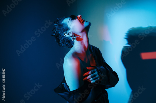 Cyberpunk model with bare shoulder laughing with head thrown back photo